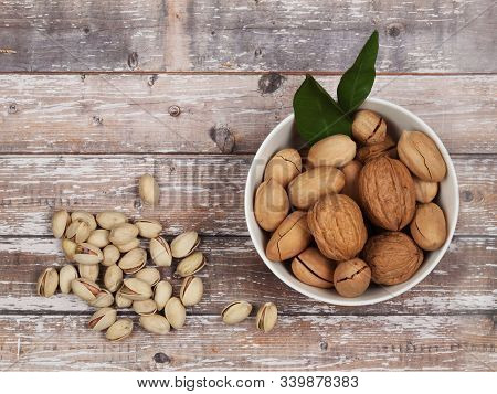 Raw Inshell Nuts On Brown Wooden Background. Top View With Copy Space