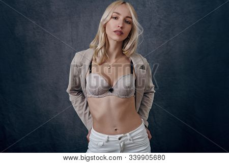 Attractive Young Blond Woman With Opened Blazer Showing Her New Bra And Giving The Camera A Sultry L