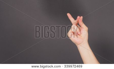 Male Model Is Doing Snap Gesture Hand Sign On Black Background.