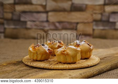 Traditional Italian Pastries Soffioni On A Cutting Board. Stone Wall In The Background. Close Up.