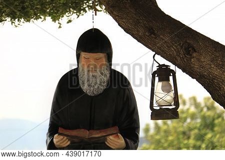 A Statue Of The Lebanese Saint Mar Charbel Reading A Book.