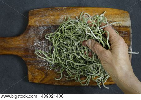 Raw Spaguetti. Hand Taking The Pasta Before Cooking