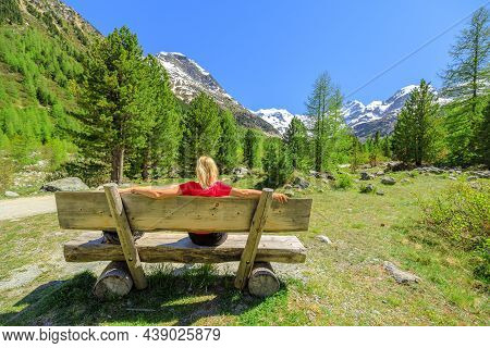 Backpacker Girl With Red T-shirt On The Trekking Bench To Morteratsch Glacier Of Switzerland. Bigges