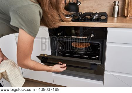 Woman Open Electric Oven Door To Chek In Baking Cake. Homemade Cooking. Kitchen Appliance