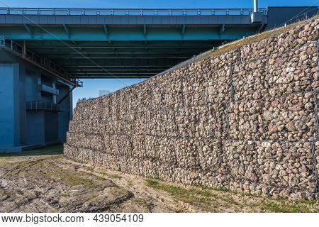 Engineering Structure Made Of Stones Behind Metal Wire Netting To Strengthen The River Bank Near The