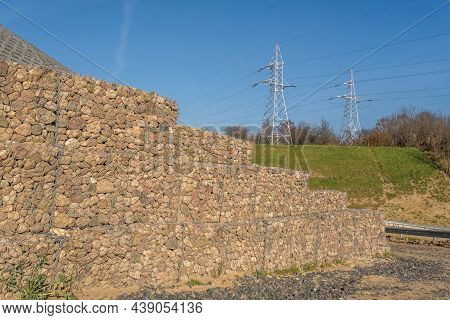 Engineering Structure Made Of Stones Behind Metal Wire Netting To Strengthen The River Bank Near The