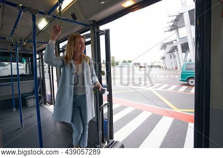 Straphanger With Boarding Ticket And Baggage Riding Airport Shuttle Bus