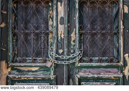 Wooden, Antique Door, Closed With An Iron Chain And Padlock. Close-up.