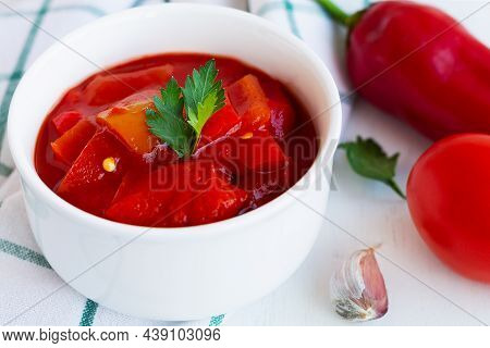 Close-up Lecso National Dish Of Hungarian Cuisine With Pepper And Tomato, Greens On The White Plate.