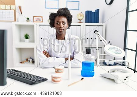 African dentist woman working at medical clinic skeptic and nervous, disapproving expression on face with crossed arms. negative person. 
