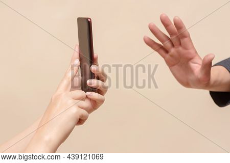 Do Not Shoot Concept. No Photo. One Person With Smartphone Photo Camera In Hand And Stop Gesture By 