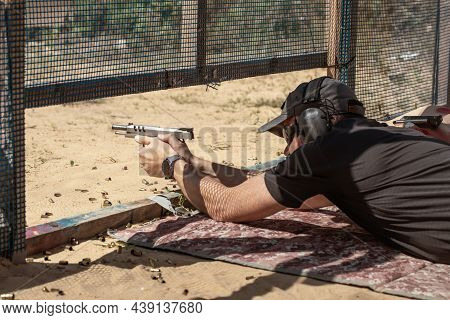 Man In Tactical Clothes Shooting From A Pistol, Reloading The Gun And Aiming At The Target In The Op