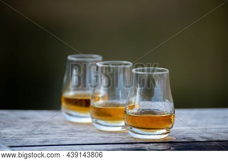 Tasting Glasses Of Scotch Whisky Strong Drink On Old Outdoor Wooden Table