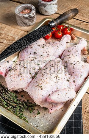 Cooking Raw Spatchcocked Whole Chicken With Garlic And Thyme In Baking Dish. Wooden Background. Top 