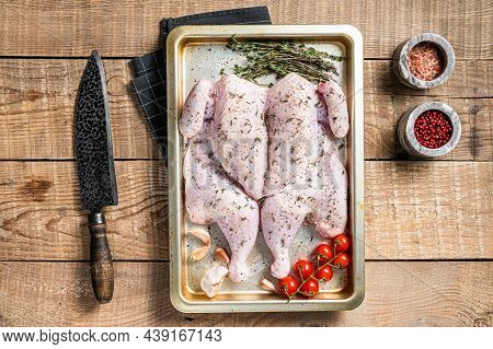 Cooking Raw Spatchcocked Whole Chicken With Garlic And Thyme In Baking Dish. Wooden Background. Top 