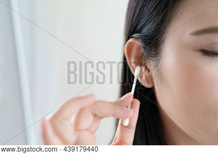 Woman Cleaning Ear With Cotton Swab. Healthcare And Ear Cleaning Concept