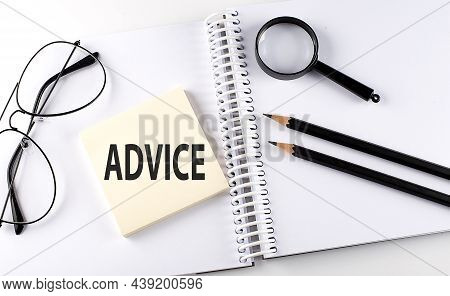 Word Advice On The Sicker On The Notebook With Pencils,magnifier And Glasses