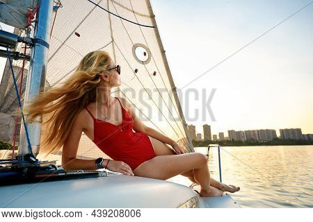 Young Beautiful Woman In Fashion Red Swimsuit Standing On Yacht In Open Sea Or Ocean, Sailing