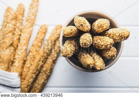 Breadsticks grissini. Bread sticks with sesame seeds in cup. Top view.