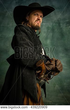 Cropped Portrait Of Brutal Horrendous Man, Medeival Pirate In Hat Isolated Over Dark Background.