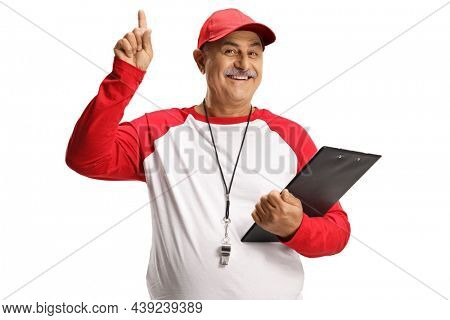 Mature baseball coach with a wistle and a clipboard pointing up isolated on white background