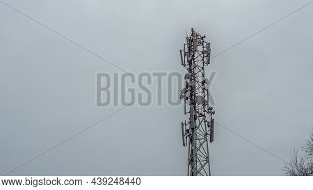 Tower With Mobile Operator Antennas On The Dramatic Sky Background. Tower Hosted Equipment Cellula. 