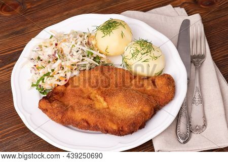 Chop pork tenderloin cutlets served vith boiled potatoes and vegetable salad