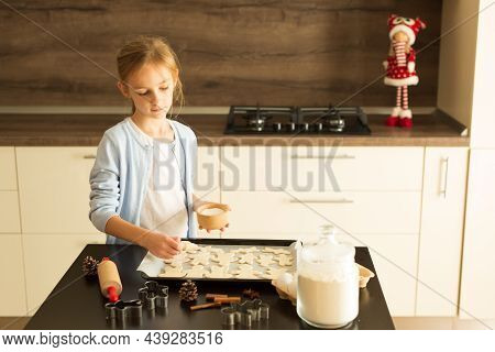 Girl In A White Shirt And A Blue Sweater Sprinkles Sugar On Christmas Coocies Before Baking. Differe
