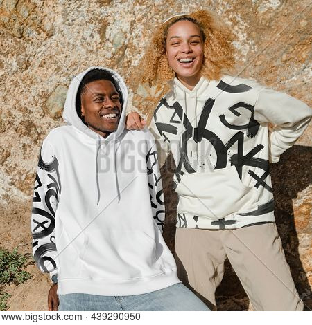 Happy couple in stylish hoodies for winter outdoor shoot