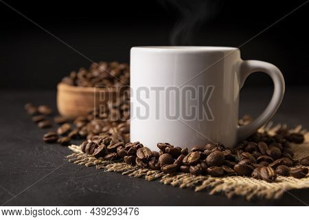 White Lungo Cup With Hot Coffee Drink And Toasted Coffee Beans Scattered On A Rustic Black Table. Cl