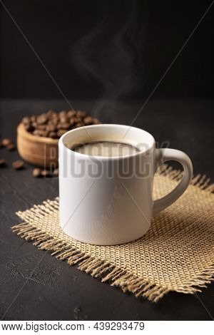 White Lungo Cup With Hot Coffee Drink And Toasted Coffee Beans Scattered On A Rustic Black Table. Cl