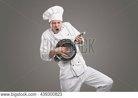 Funny Male Cook In White Uniform Pretending Being Crazy Guitarist Playing Colander Impromptu Guitar 
