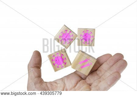 A Hand And Levitating Wooden Cubes Embossed With Pink Viral Symbols And Needles Icons. Covid-19 Vaci