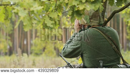 Hidden Re-enactor Dressed As German Wehrmacht Infantry Soldier In World War Ii Soldier Sitting In Am