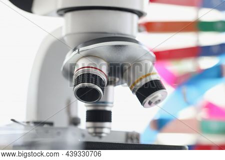 Microscope Standing Near Multicolored Model Of Dna Chain In Lab. Screening For Hereditary Genetic Di