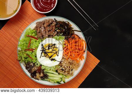 Pibimpap, A Korean Dish Of Boiled Rice, Various Vegetables And Pickled Beef, Served With Fried Egg, 