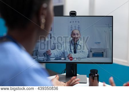 African American Asisstant Discussing Flu Symptoms With Remote Physician Doctor During Online Videoc