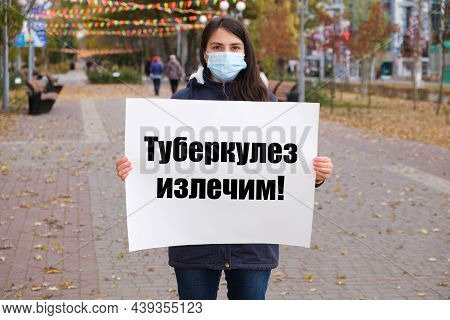 A Masked Woman Holds A Poster With Text In Russian, Translated From Russian - Tuberculosis Is Curabl