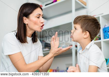 Cute Woman Speech Therapist Teaches Child To Pronounce Words Sounds And Letters Correctly In Office