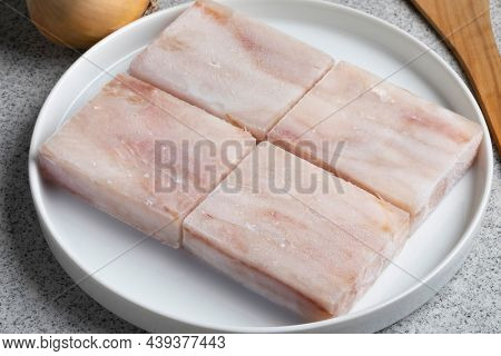 Dish with pieces of frozen Pollock fish fillet as an ingredient for cooking close up  