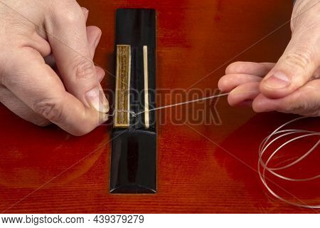 Replacement And Insertion Of Nylon Strings In A Classical Guitar. Lesson For A Musician