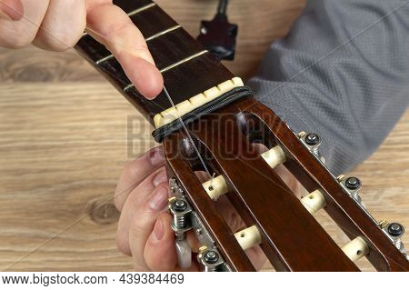 Changing Nylon Strings On A Six-string Classical Guitar. Instruction For Musician
