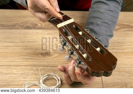 Changing Nylon Strings On A Six-string Classical Guitar. Instruction For Musician