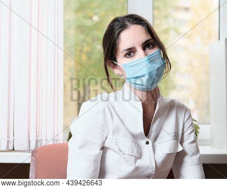 Tired Exausted Asian Woman Doctor In A Clinic. Hospital Rest Room. Woman Wearing Medical Uniform And