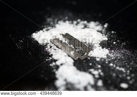Razor Blade On Drug Powder On Reflection Black Background.copy Space.