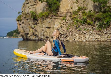 Young Women Having Fun Stand Up Paddling In The Sea. Sup. Red Hair Girl Training On Paddle Board Nea