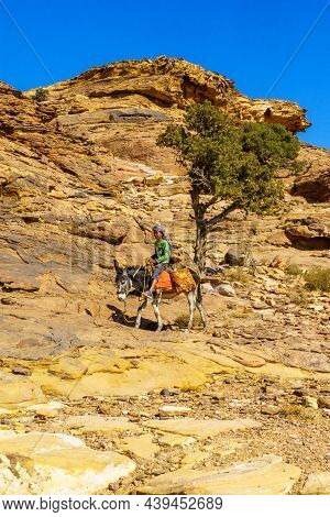 Petra, Jordan - October 24, 2021: View Of Desert Mountain Landscape, With Local On A Donkey, Near Pe