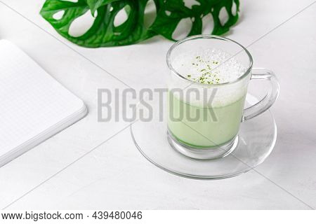 Matcha Latte With Foam On Plant-based Milk In Glass Cup On The White Desk. Hot Healthy Drink
