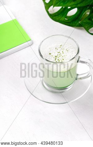 Matcha Latte With Foam On Plant-based Milk In Glass Cup On The White Desk. Hot Healthy Drink