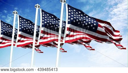 Four Flags Of The United States Of America Waving In The Wind. Clear Sky In The Background. Selectiv